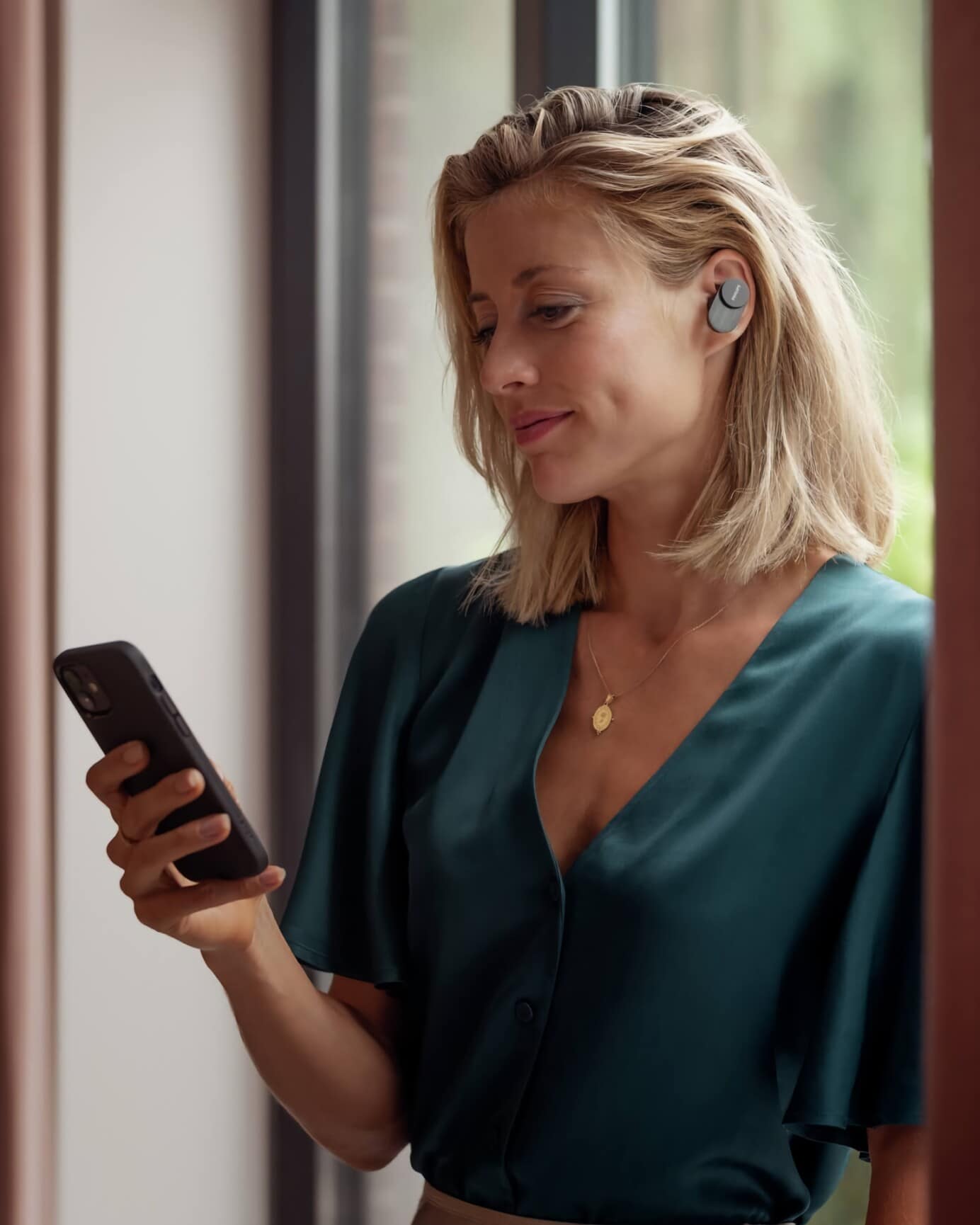 Žena používajúca smartfón a slúchadlá Philips Fidelio T1