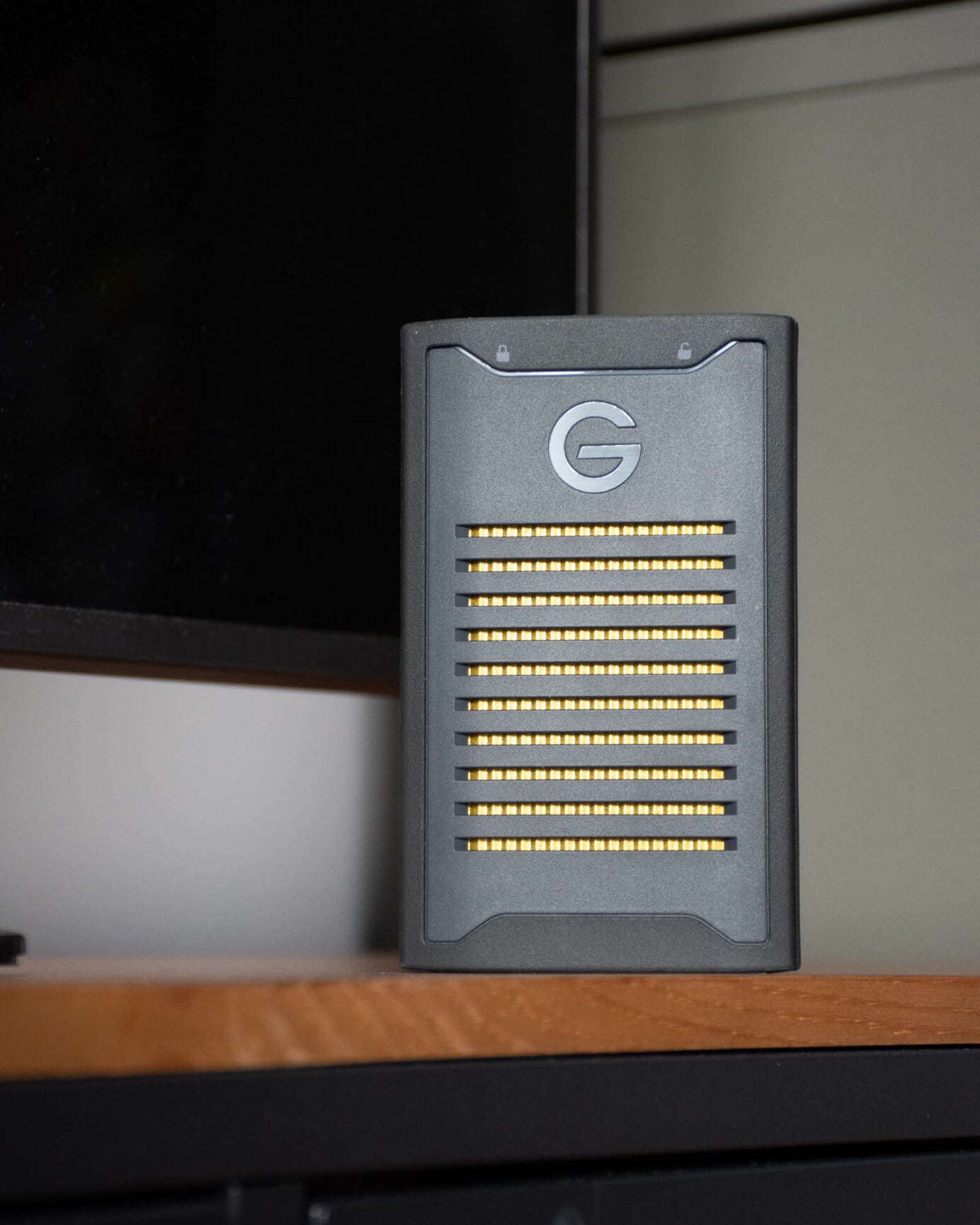G-DRIVE ArmorLock SSD vertikálne položený na dreve.